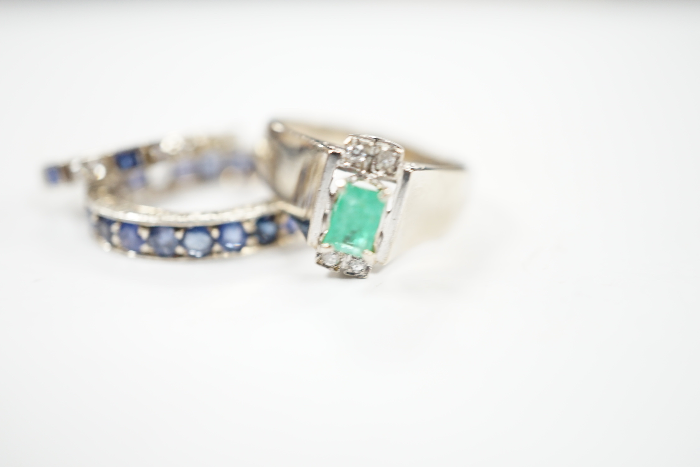 An 18k white metal, emerald and diamond set dress ring, size O, a white metal and sapphire set full eternity ring (stones missing) and an 18ct, sapphire and diamond set half hoop ring, gross weight 10 grams.